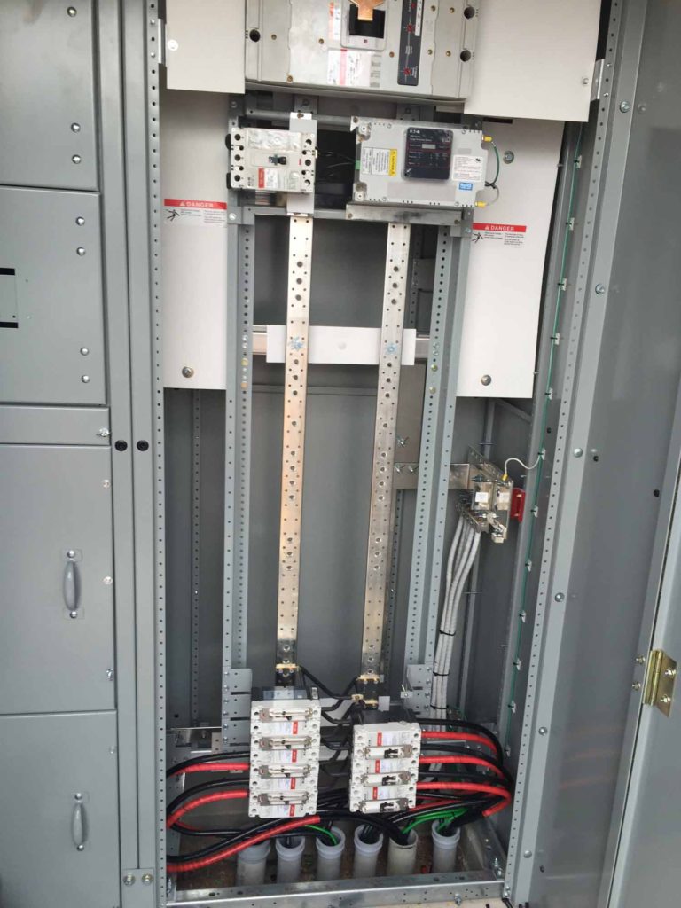 A large metal door with two locks and many wires.